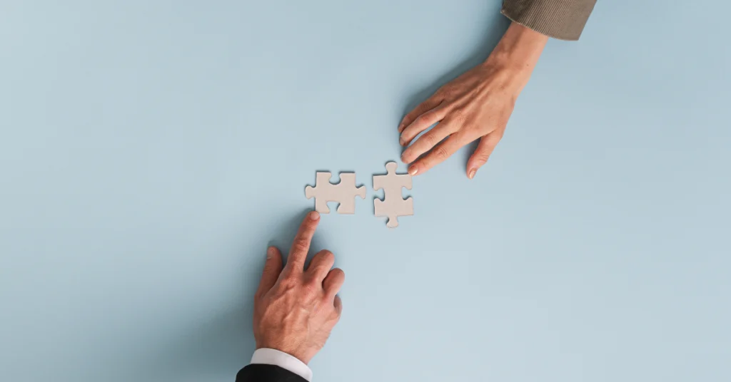 two hands with a piece of a puzzle