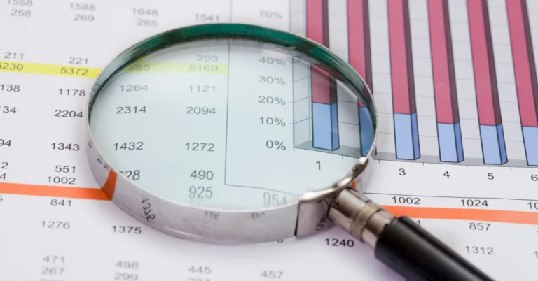 Magnifying glass over financial charts and data tables