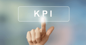 A hand pressing a glowing virtual button labeled “KPI” on a blurred background.